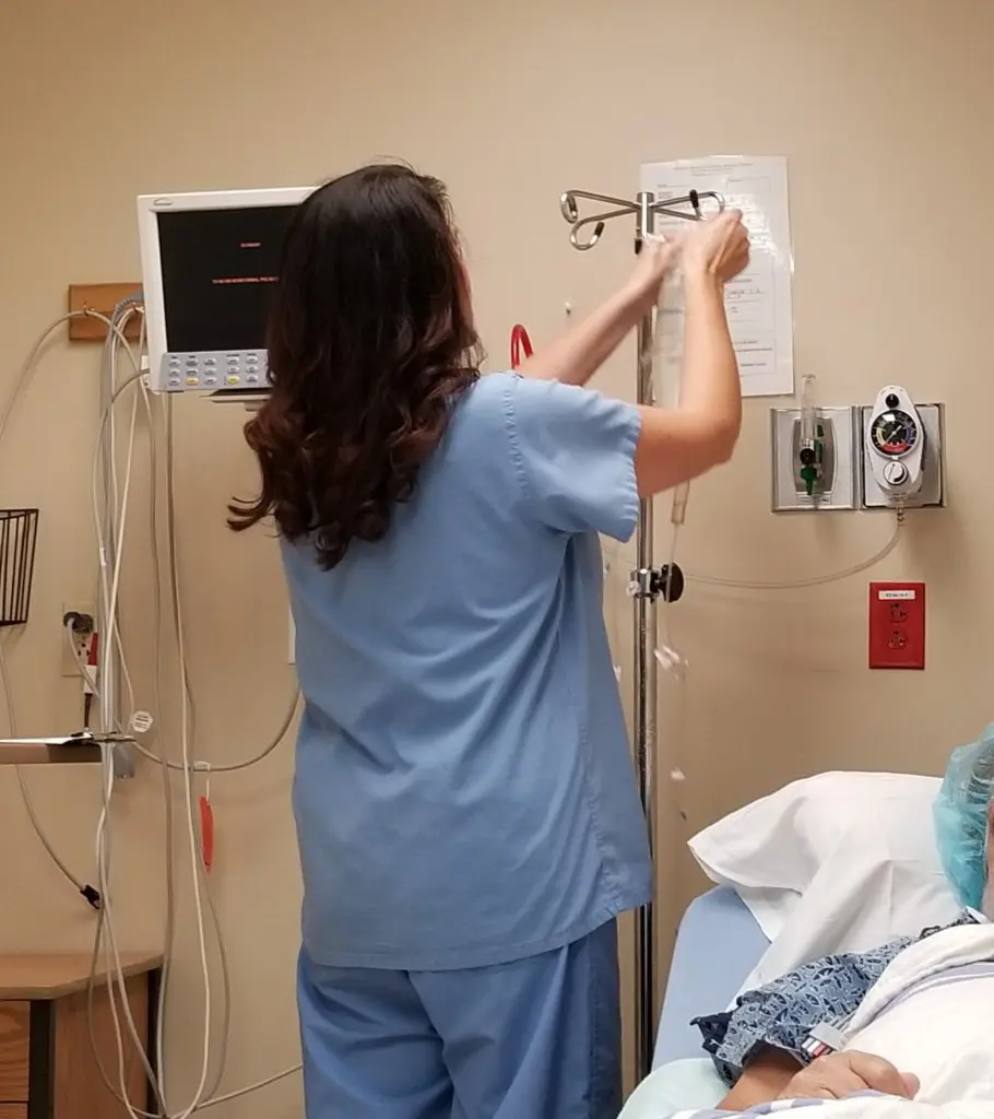 Nurse Hanging a Bag on an IV Pole